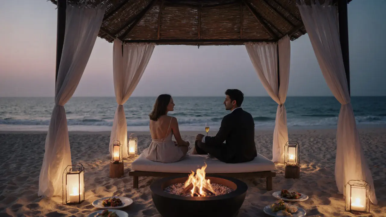 Couple relaxing on a private beach at dusk with lanterns and a fire pit nearby.