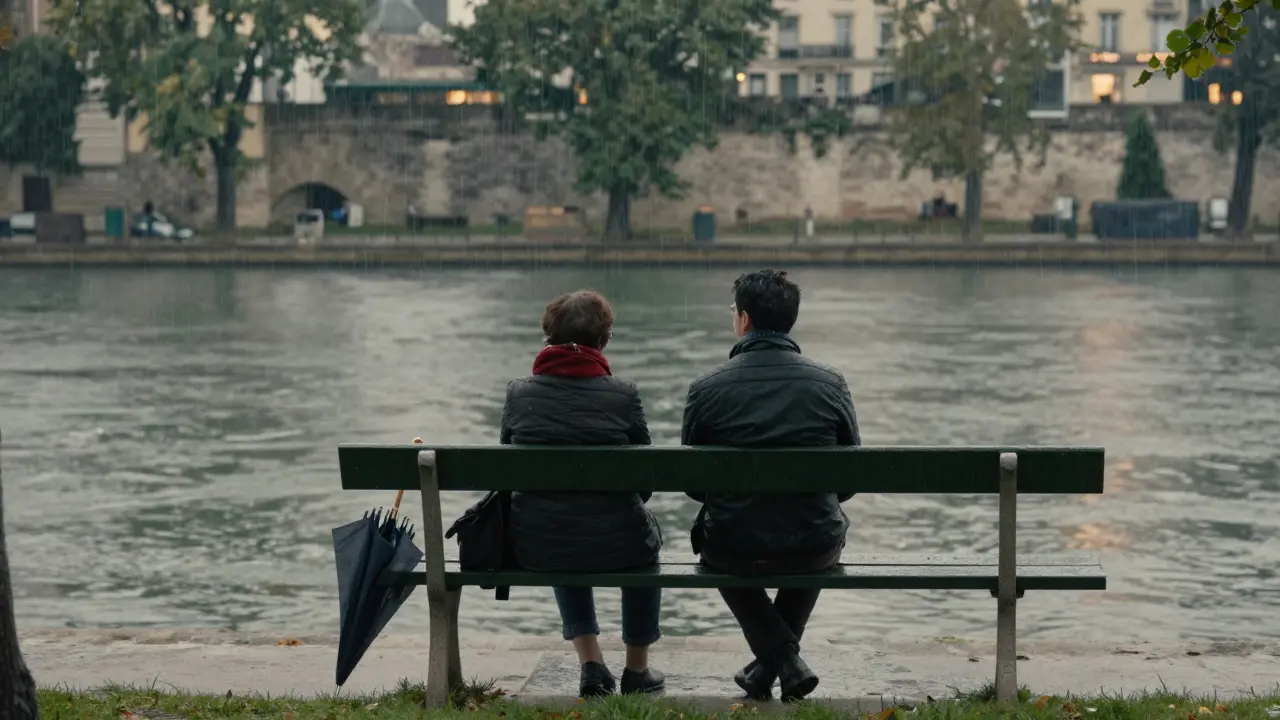 Two people sitting quietly on a park bench watching rain on the Seine, soft focus.